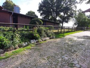 a gravel road next to a fence and a building at Ferienwohnung Noltenius 2 in Bülstedt