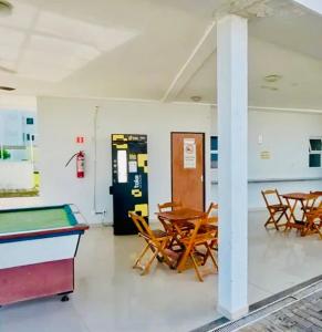 a room with a pool table and chairs and a soda machine at Apartamento confortável para sua estadia in Teresina