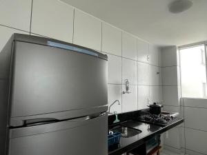a kitchen with a stainless steel refrigerator and a sink at Apartamento confortável para sua estadia in Teresina