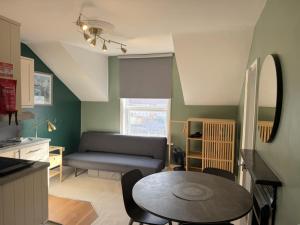 a kitchen and living room with a table and a couch at Melbury Rooms & Studios in Exeter