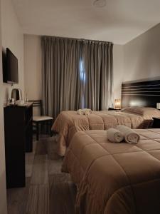 a hotel room with two beds and a desk at Achalay Hotel Boutique Colonia Dora in Colonia Dora
