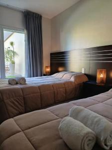 a hotel room with two beds and a window at Achalay Hotel Boutique Colonia Dora in Colonia Dora