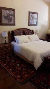 a bedroom with a large white bed with two lamps at House Rossini in Pretoria