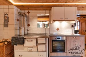 a kitchen with white appliances in a room at Selbstversorgerhaus Herisch in Schladming