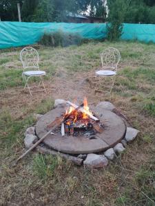 a fire pit with two chairs and two fires at Casa Valle Verde in Sierra de los Padres