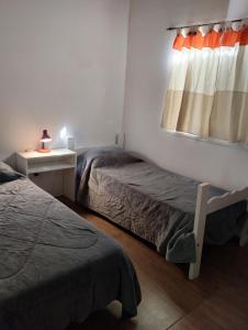 a room with two beds and a window at Casa Valle Verde in Sierra de los Padres
