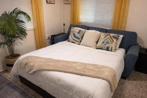 a bedroom with a large bed with pillows and a plant at King Suite and Sofa Bed Fast WI-FI Easy DC Access in District Heights