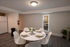 a dining room with a white table and white chairs at King Suite and Sofa Bed Fast WI-FI Easy DC Access in District Heights