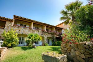 a large house with a palm tree and a yard at L' Escapade Hôtel & Restaurant in Le Pradet