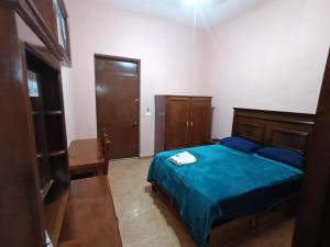 a bedroom with a bed with a blue comforter at Garcia's Suites y Hotel Villegas in Linares