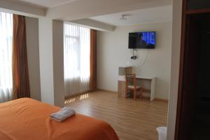 a bedroom with a bed and a tv on a wall at Kymeron Hotel in Juliaca