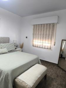 a white bedroom with a bed and a window at Oasis urbano! Apartamento Geminis complejo in San Nicolás de los Arroyos +36 photos