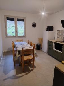 a kitchen with a table and chairs and a refrigerator at Le Lorry 8 appartement in Laruns