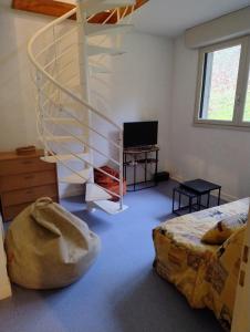 a bedroom with a spiral staircase and a bed at Le Lorry 8 appartement in Laruns