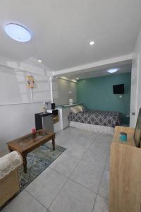 a living room with a bed and a table at Green Serene Apartments in Corinthe