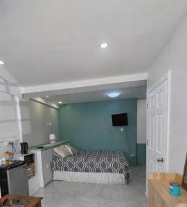 a bedroom with a bed and a blue wall at Green Serene Apartments in Corinthe