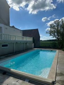 a large blue swimming pool next to a building at La Sinaise in Châteaumeillant