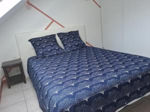 a bed with a blue and white comforter in a bedroom at welcome toEspace Zen in Levernois +7 photos