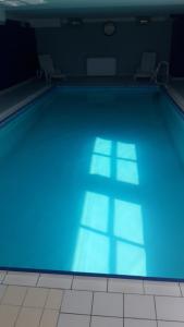 a large swimming pool with blue lighting in a room at welcome toEspace Zen in Levernois
