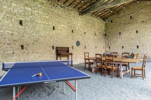 a ping pong table in a room with a brick wall at Gîtes de la Bernière in Brûlain