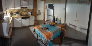a kitchen with a table and a kitchen with white cabinets at maison102 studio Saint-Ursanne Jura in Saint-Ursanne