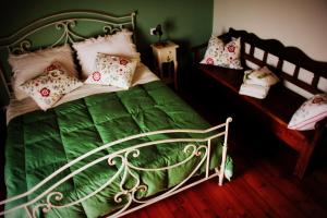 a bedroom with a green bed with pillows on it at B&B Campo del Mare in Sirolo
