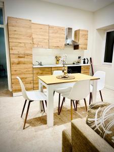 a kitchen with a dining room table and white chairs at Apparemment Cosy - Centre Auch in Auch