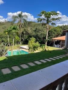 a garden with a swimming pool and a house at Sítio do Miguel in Barbacena