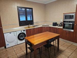 a kitchen with a table and a washer and dryer at Casona IROKO in La Costa +41 photos