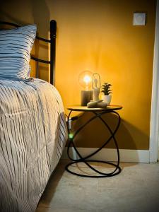 a bed with a table with a lamp on it at Apparemment Cosy - Centre Auch in Auch