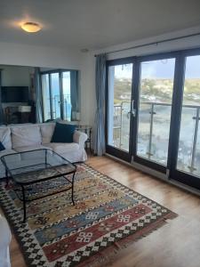 a living room with a couch and a rug at Harbour Views, Coverack in Helston