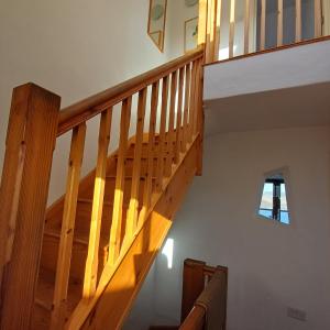 a wooden staircase in a house with a window at Harbour Views, Coverack in Helston