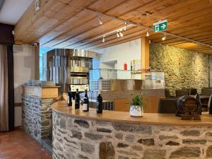 a restaurant with a counter with bottles of wine at Perla Valsole Hotel Ristorante in Acquarossa +29 photos