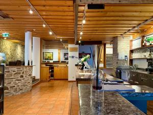 a large kitchen with wooden ceilings and a counter top at Perla Valsole Hotel Ristorante in Acquarossa