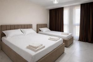 a bedroom with two beds and a window at Adan Luxury Aparthotel in Orikum