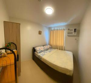 a small bedroom with a bed and a window at ONE SPATIAL 2Bedrooms Apartment Flat LLD Iloilo City Philippines in Iloilo City +41 photos