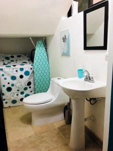 a bathroom with a sink and a toilet and a bed at La buena vida ocean Tamarindo in Tamarindo +29 photos