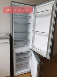 an empty refrigerator with its door open in a room at Monteurwohnung bei Nina 1OGL in Zeitz