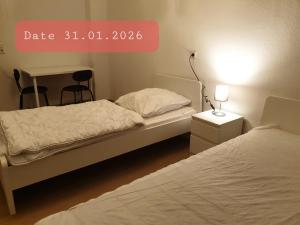 a bedroom with two beds and a table with a lamp at Monteurwohnung bei Nina 1OGL in Zeitz