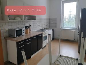 a kitchen with a sink and a microwave at Monteurwohnung bei Nina 1OGL in Zeitz +6 photos