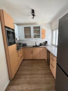 a kitchen with wooden cabinets and a black refrigerator at Ellis Häusle in Nagold +11 photos