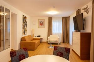 a living room with a couch a chair and a tv at Villa Viktoria 3 - Apartments in Ingolstadt