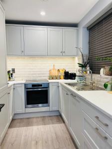 a kitchen with white cabinets and a sink at Haven Stays - D15A5DF in Tyrrelstown +8 photos