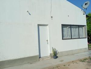 a white building with a door and a window at Los Pinos de Horizonte in Fernández