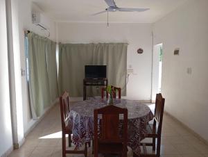 a dining room with a table and chairs and a television at Los Pinos de Horizonte in Fernández