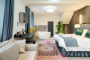 a hotel room with two beds and a bath tub at Waterhead Bath Suites - Parking and Light Breakfast in Ambleside
