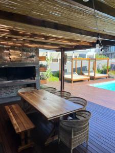 a wooden table on a deck with a fireplace at Oppi See Beach House in Wilderness