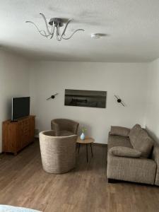a living room with two chairs and a tv at Ferienwohnung am Netzener See in Lehnin