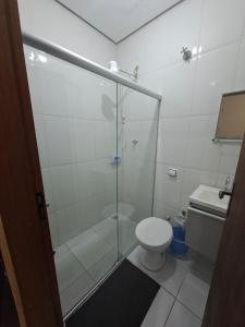 a bathroom with a glass shower with a toilet at Hotel Padre Vitor in Aparecida