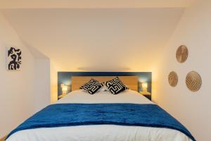 a bedroom with a bed with two pillows on it at La Perle Bleue in Algrange +30 photos